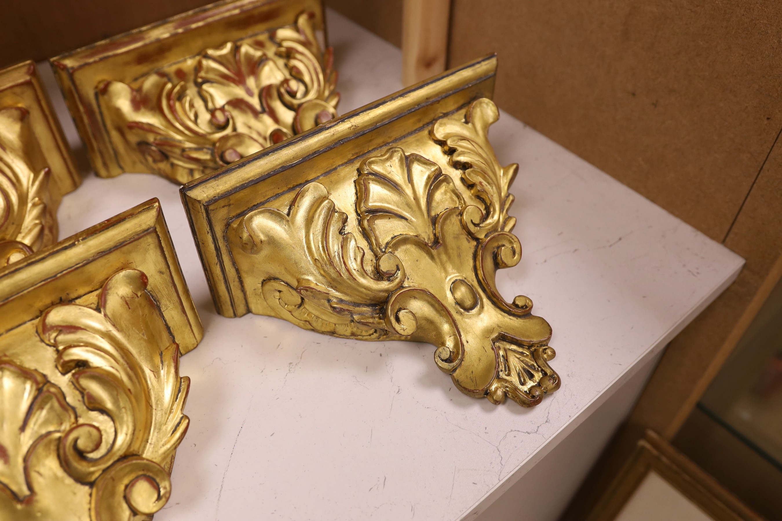 A set of four gilt wood wall brackets, 18.5cm tall x 24cm wide